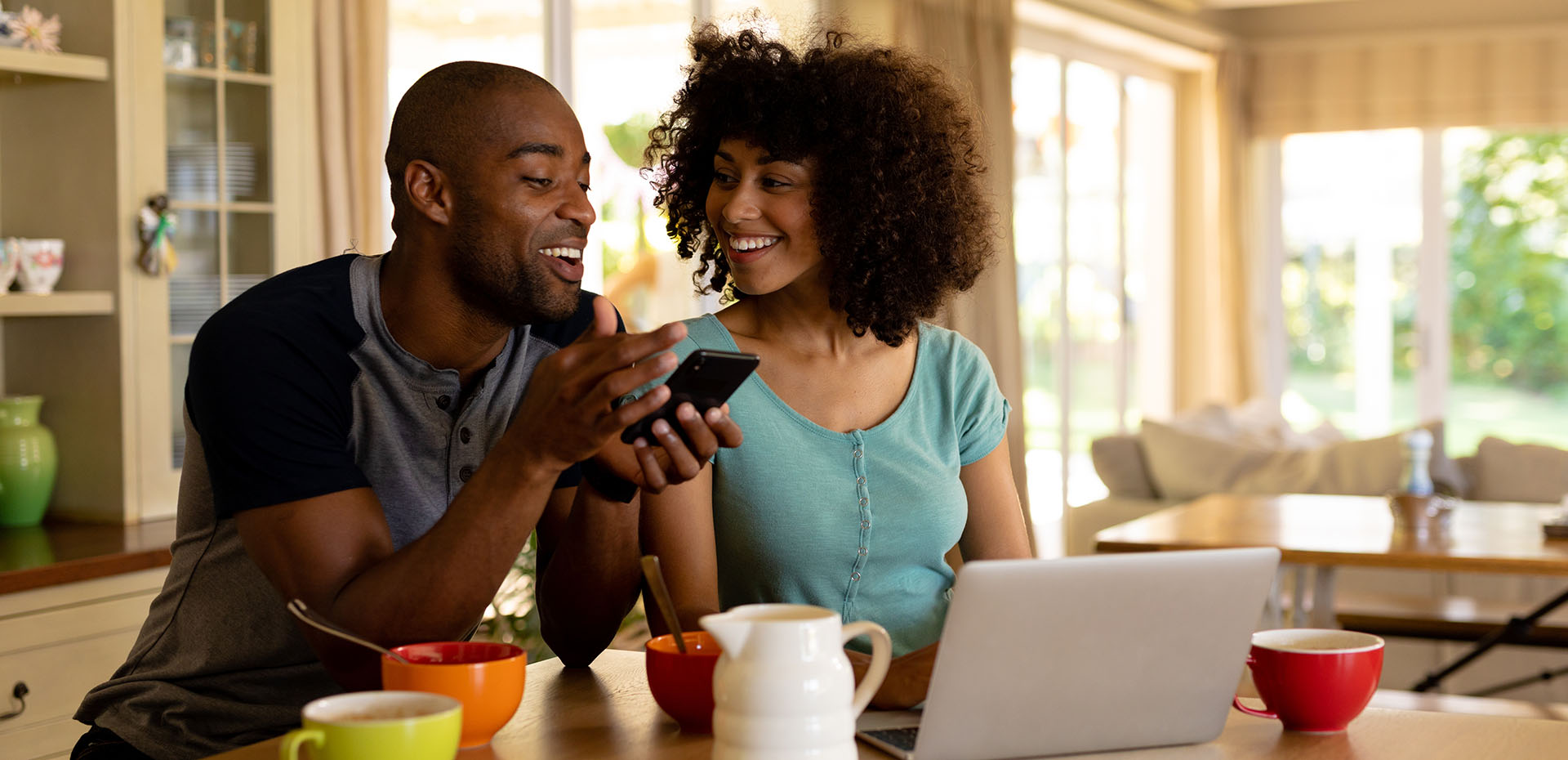 Image showing a happy couple on the phone in front of their laptop