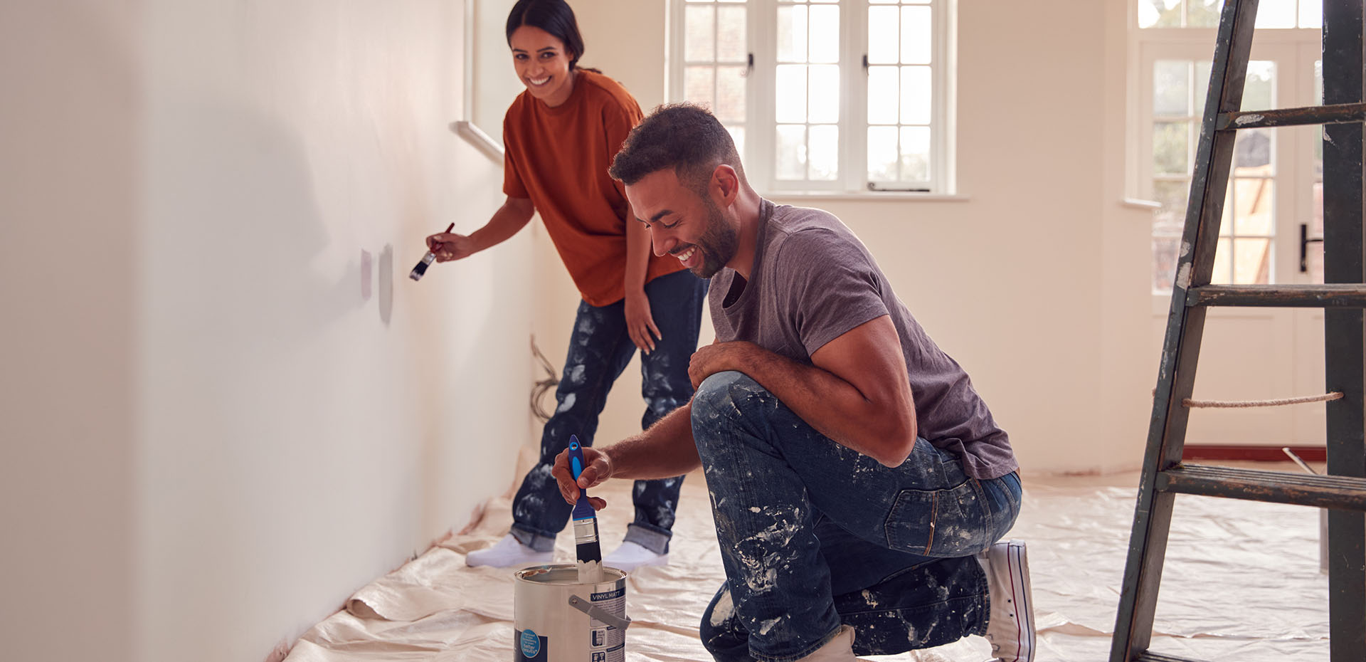 Image showing a happy couple painting samples on the wall