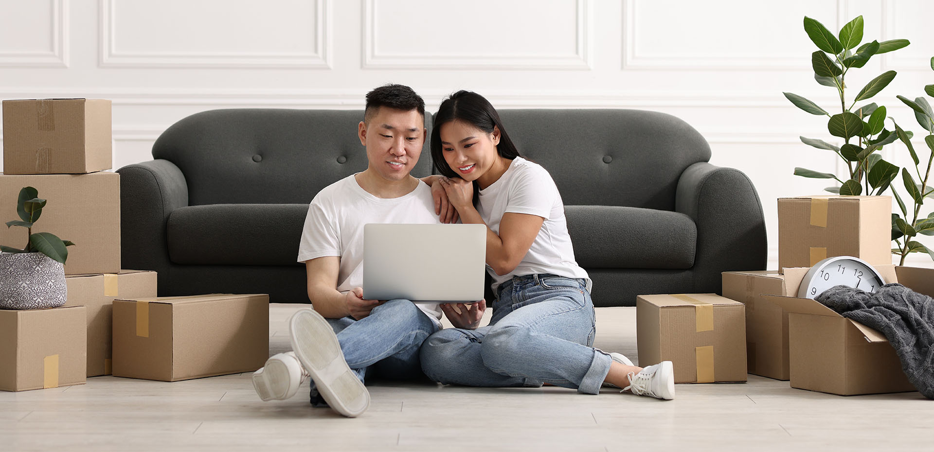 Image showing a couple on their laptop surrounded by boxes