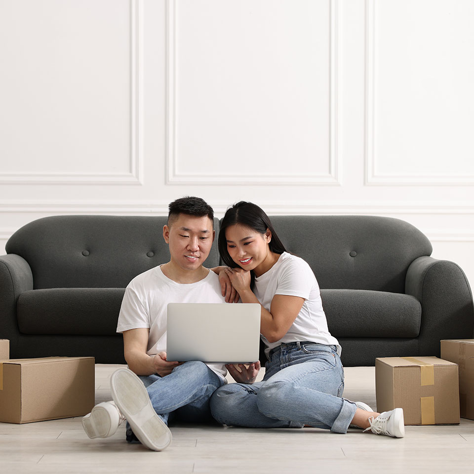 Image showing a couple on their laptop surrounded by boxes