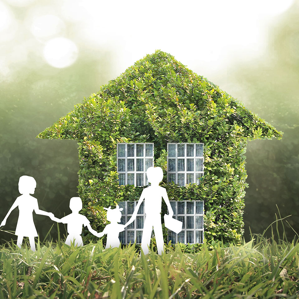 Image showing a paper cut out family in front of a model house