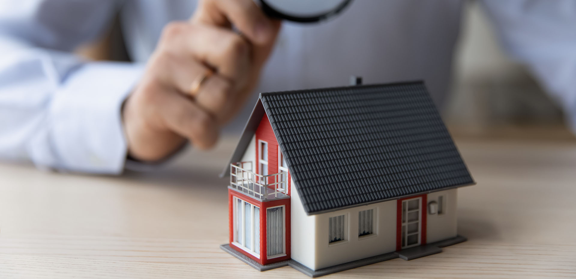 Image showing a magnifying glass being held over a model house