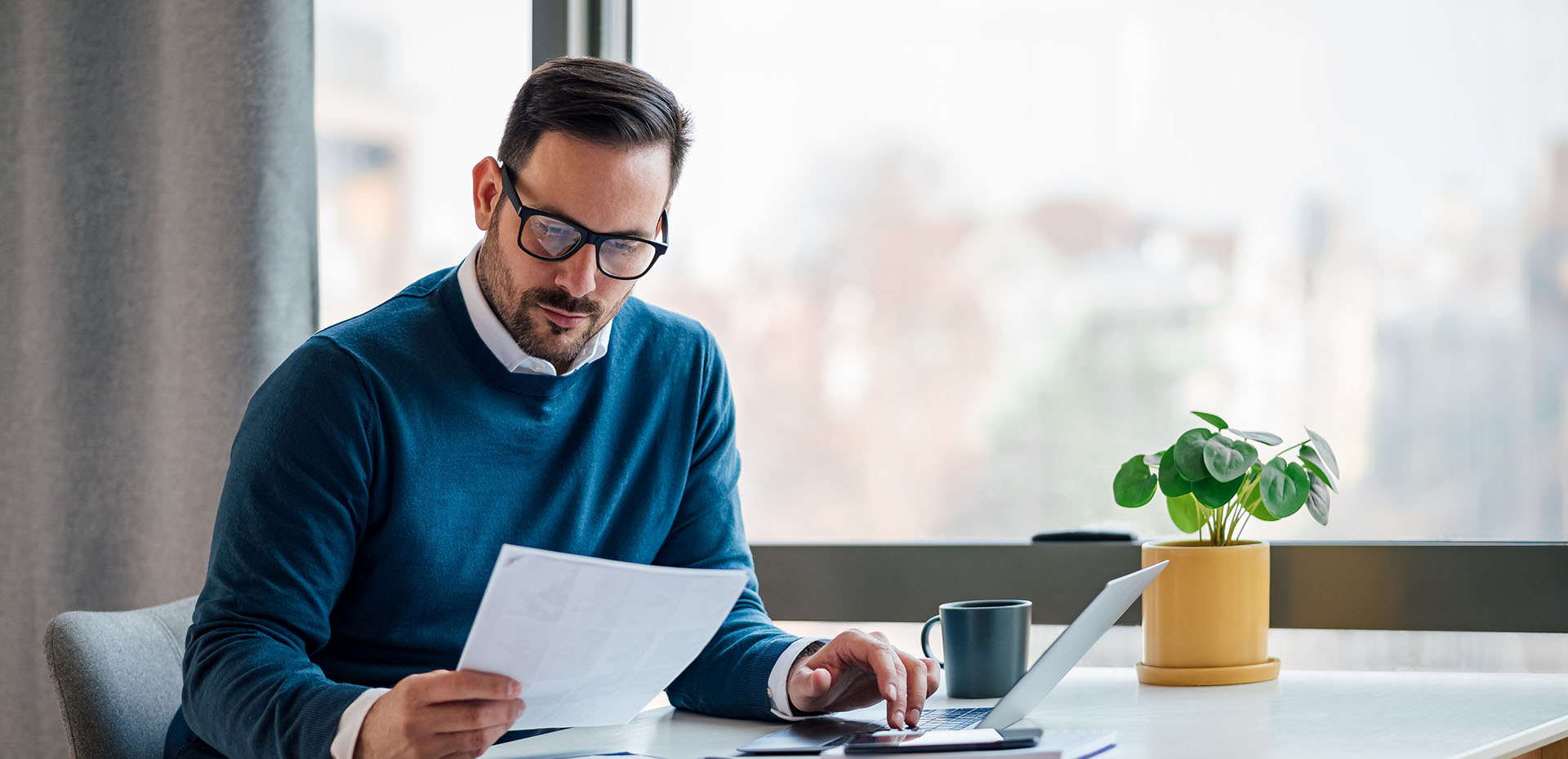 Image showing a man on his laptop looking at some paperwork