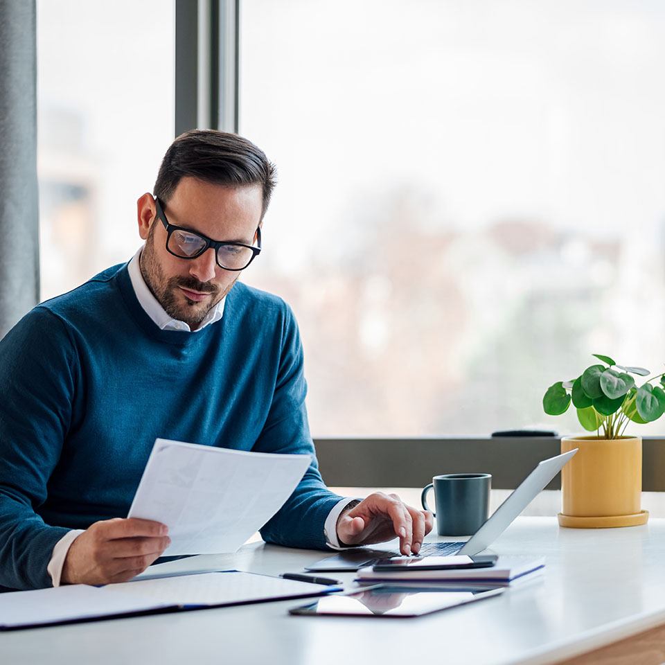 Image showing a man on his laptop looking at some paperwork