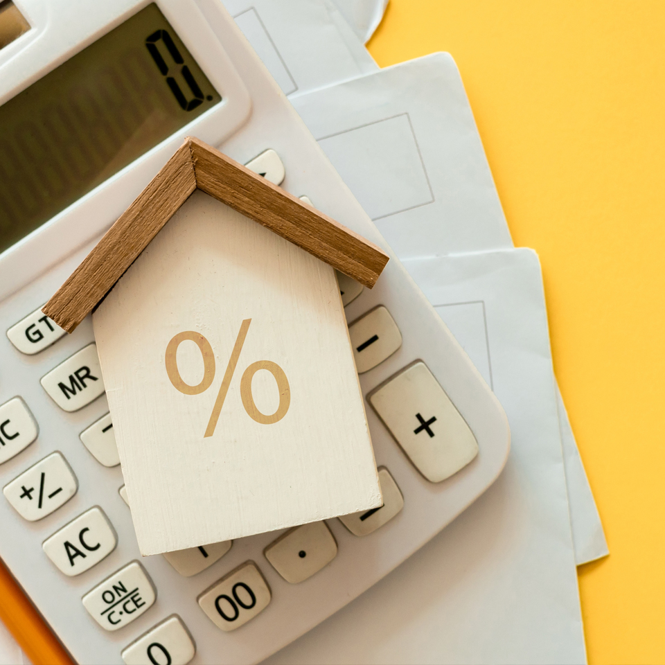 image showing a wooden house on top on a calculator