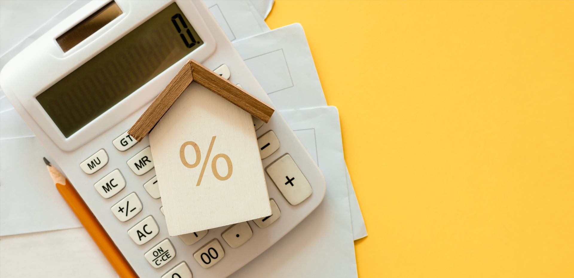 image showing a wooden house on top on a calculator
