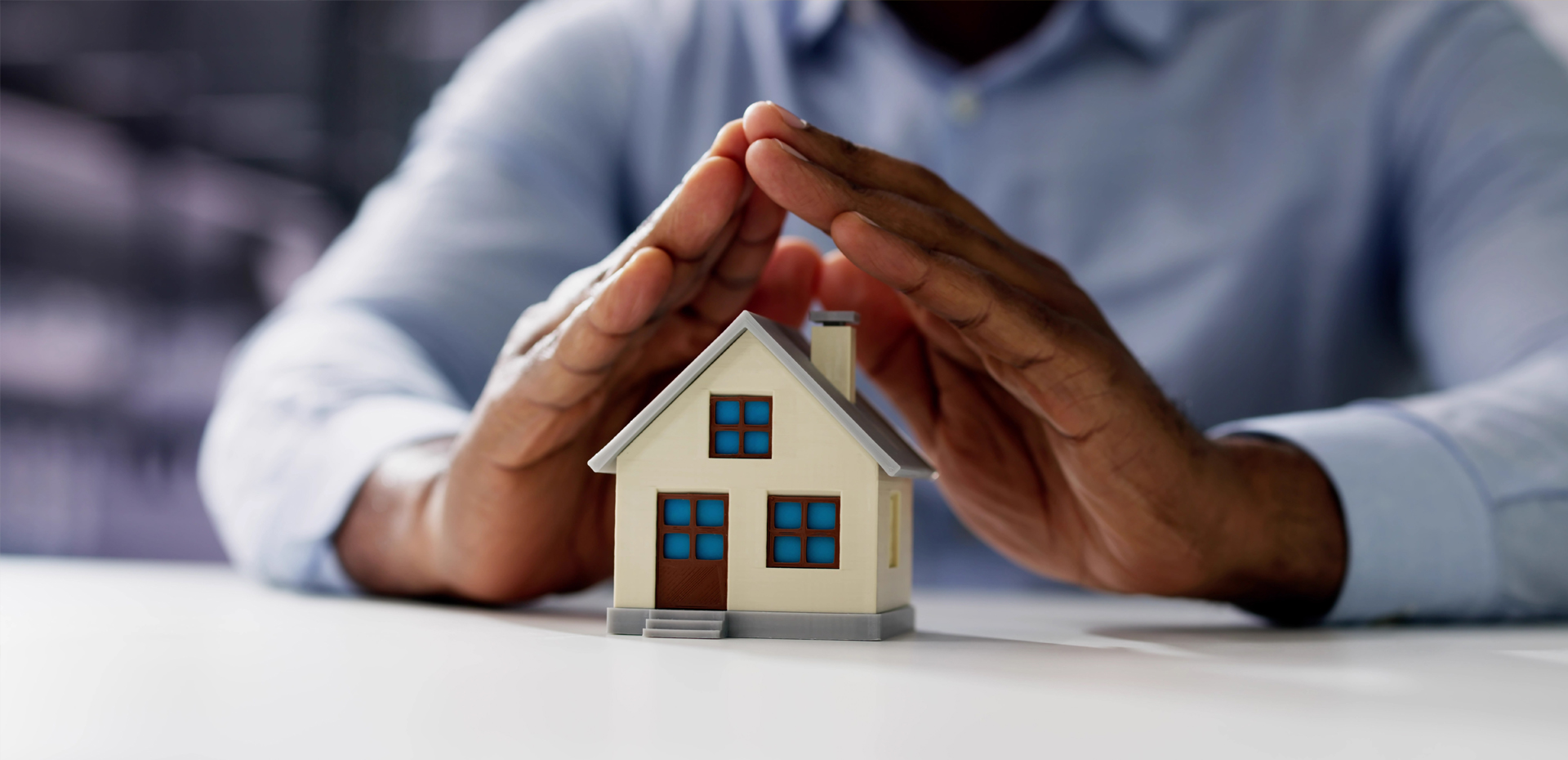 image showing hands protecting a house
