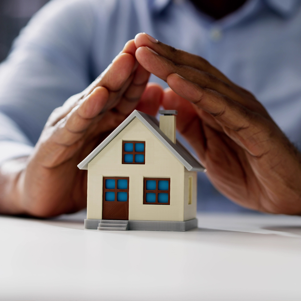 image showing hands protecting a house