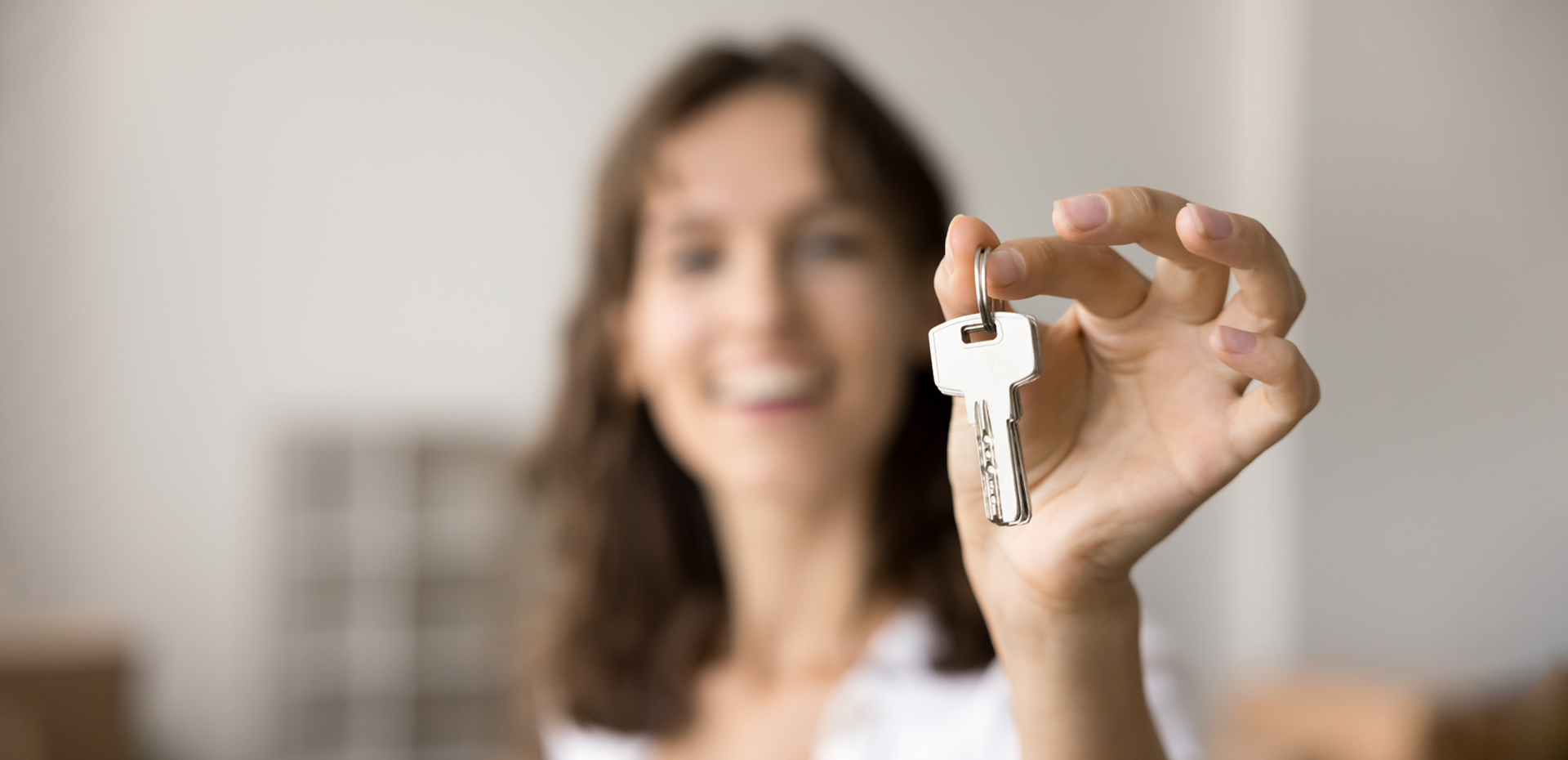 image showing a lady holding a house key