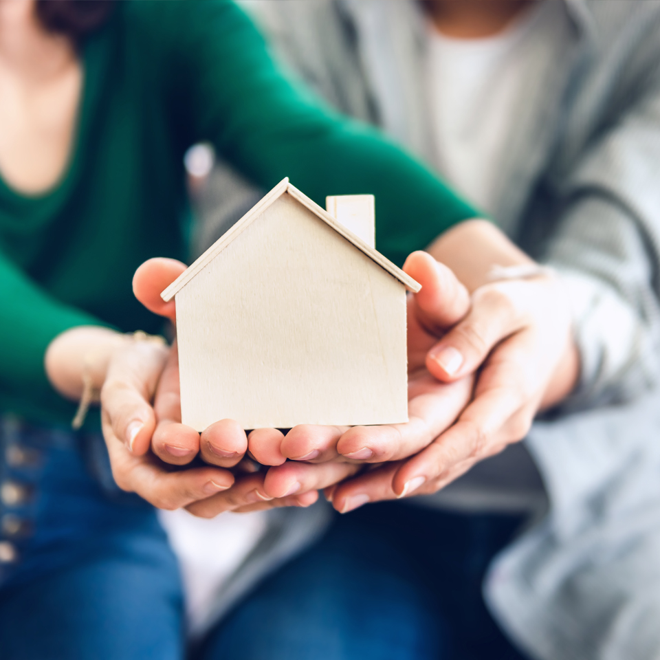 Couple Hands Holding Housing Model