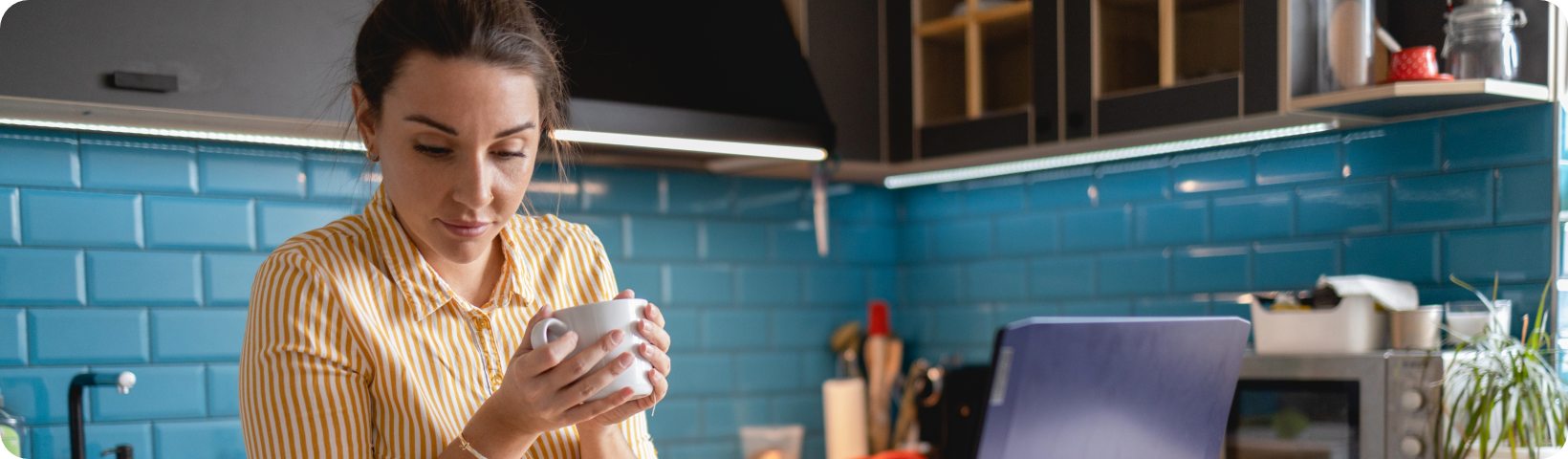 Image showing a woman sat at a table using her laptop