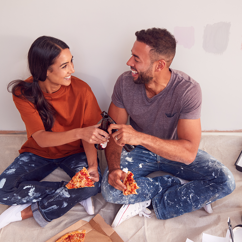 Image showing a couple sitting on the floor eating pizza