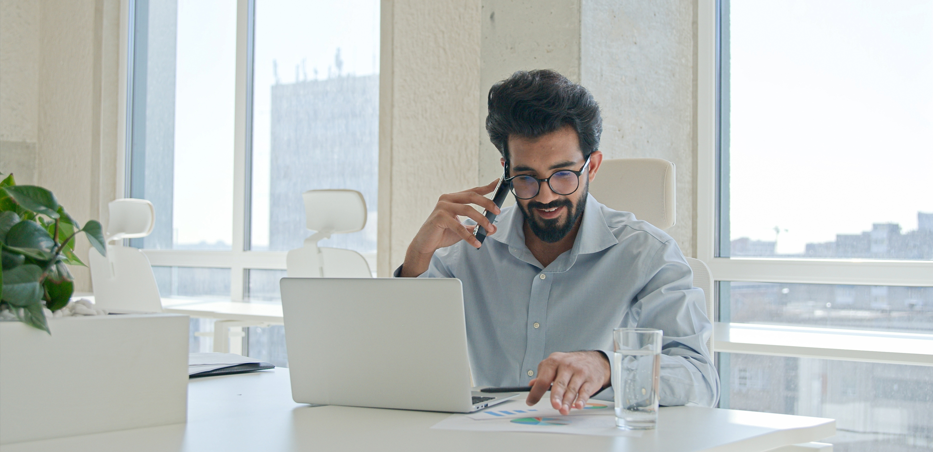 Image showing a man sitting at a desk on the phone