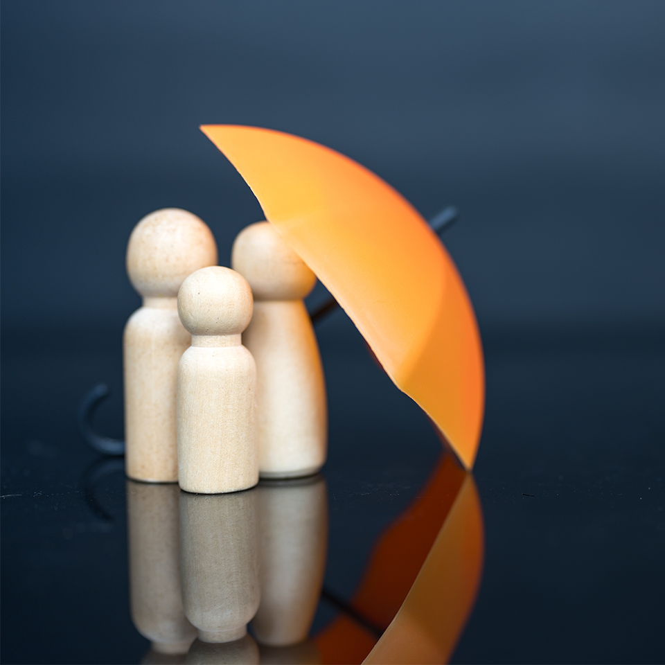 Image showing a wooden family being protected by an umbrella